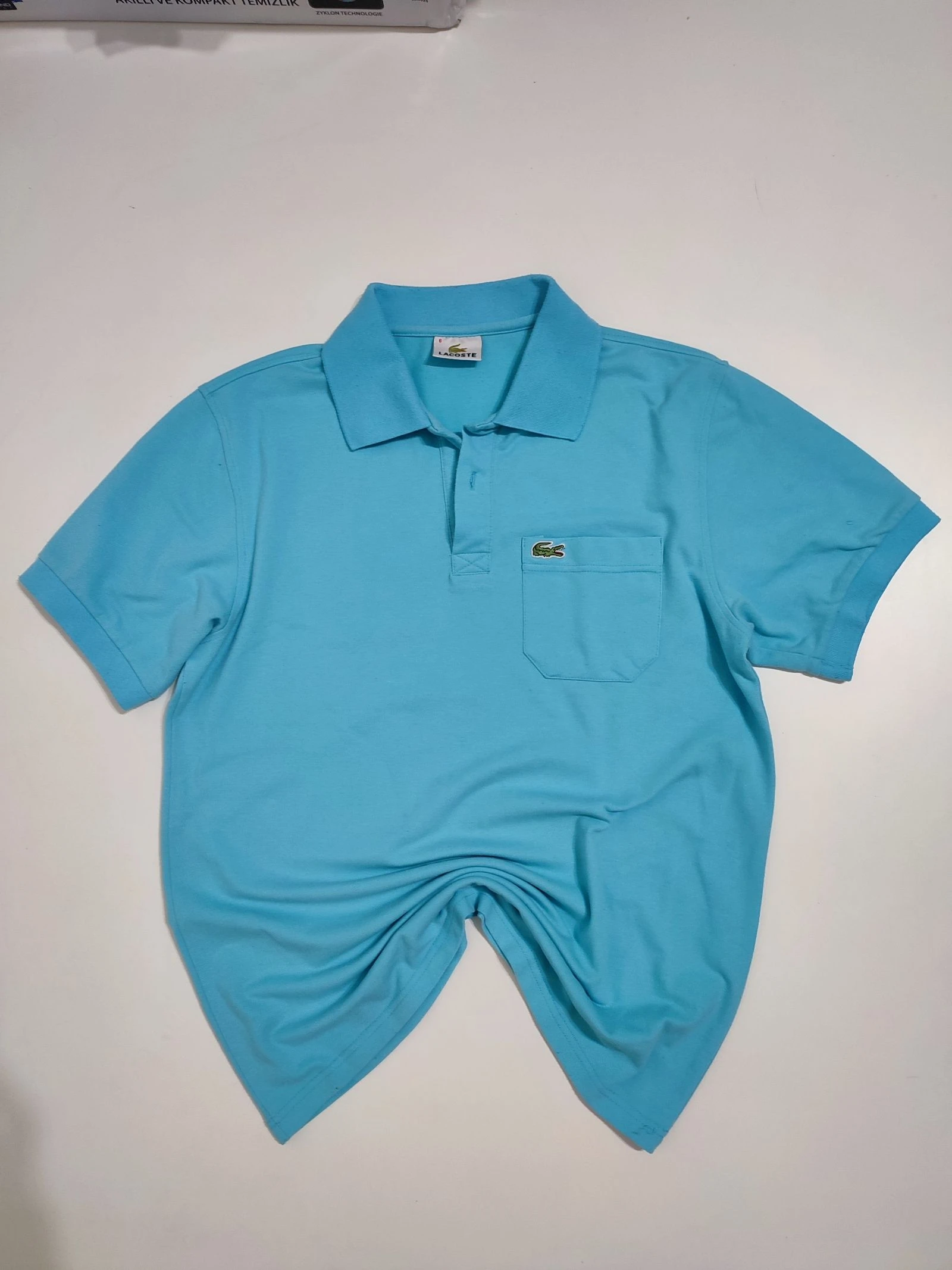 Polo Lacoste vintage celeste con bolsillo Talla 6 (XL)